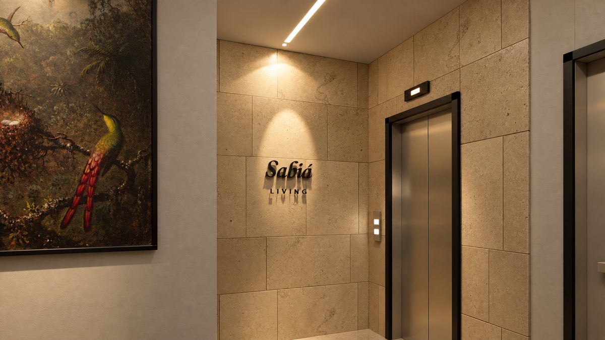 Hall do elevador em pedra bege com a marca Sabiá Living na parede e um quadro de pássaro